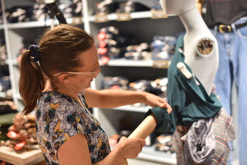 Une femme réalisant l'habillage d'un mannequin